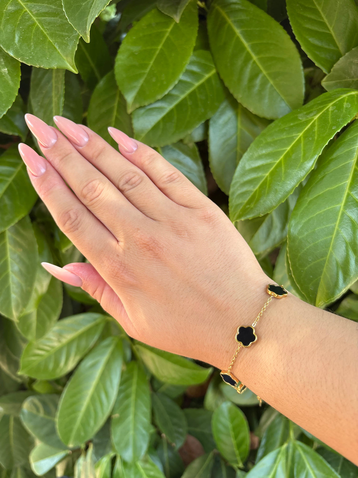 Bracelet fleurs noires doré porté au poignet