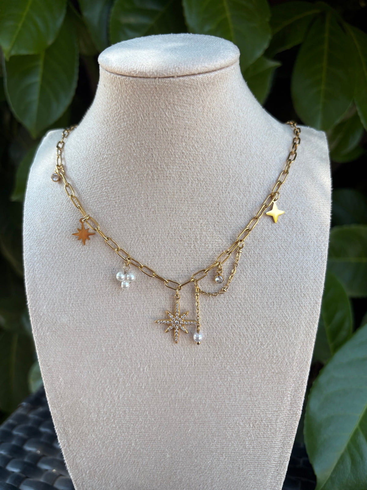 Collier breloques étoiles perles et strass doré sur présentoir