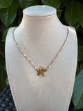 Collier pendentif fleur dorée sur chaîne de perles blanches