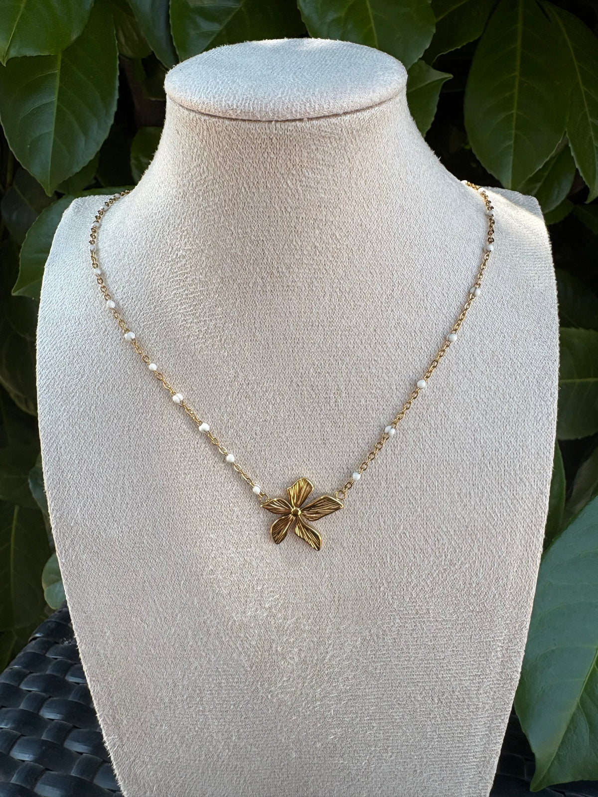 Collier pendentif fleur dorée sur chaîne de perles blanches