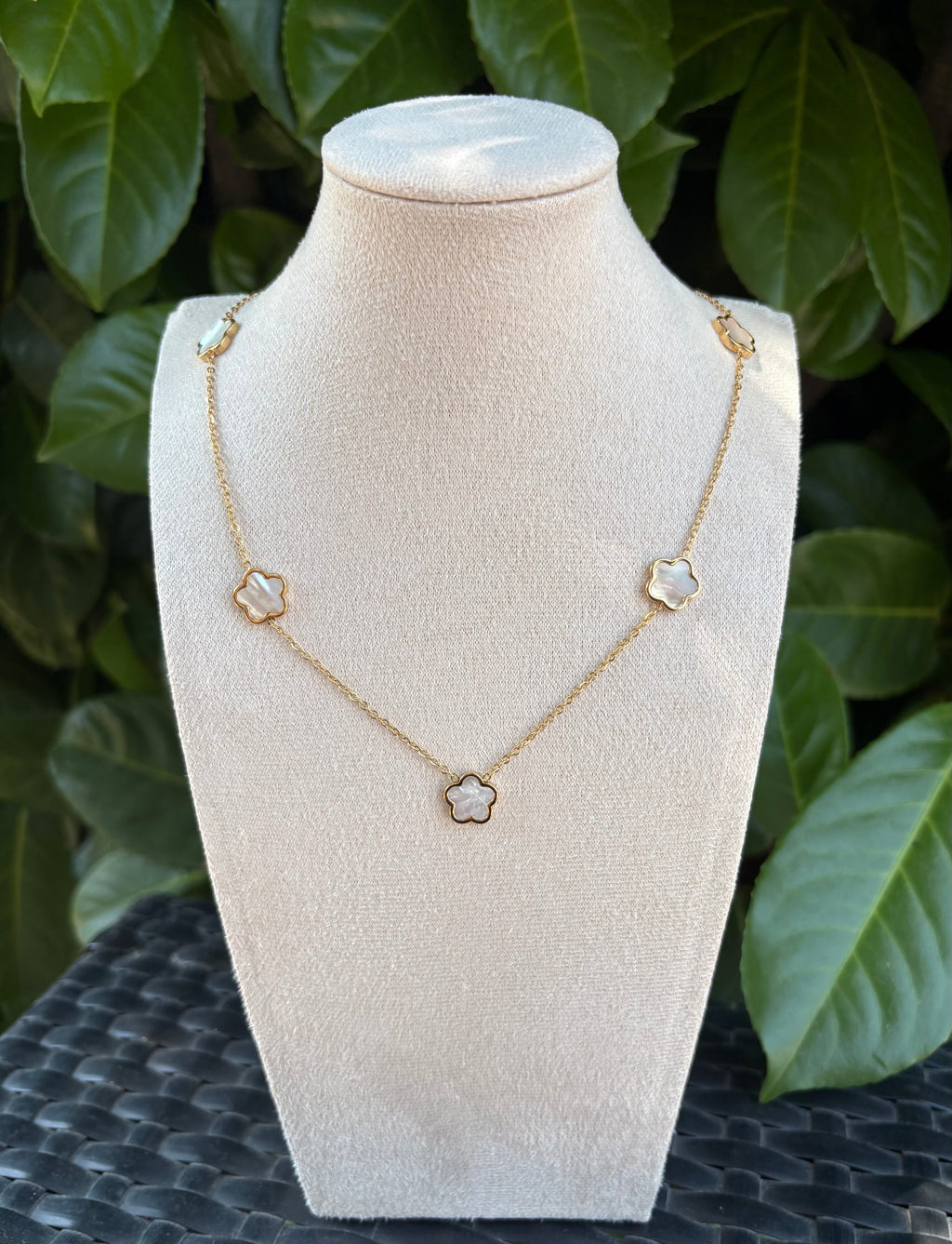 Collier fleurs blanches nacrées doré sur présentoir