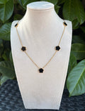 Collier fleurs noires doré sur présentoir