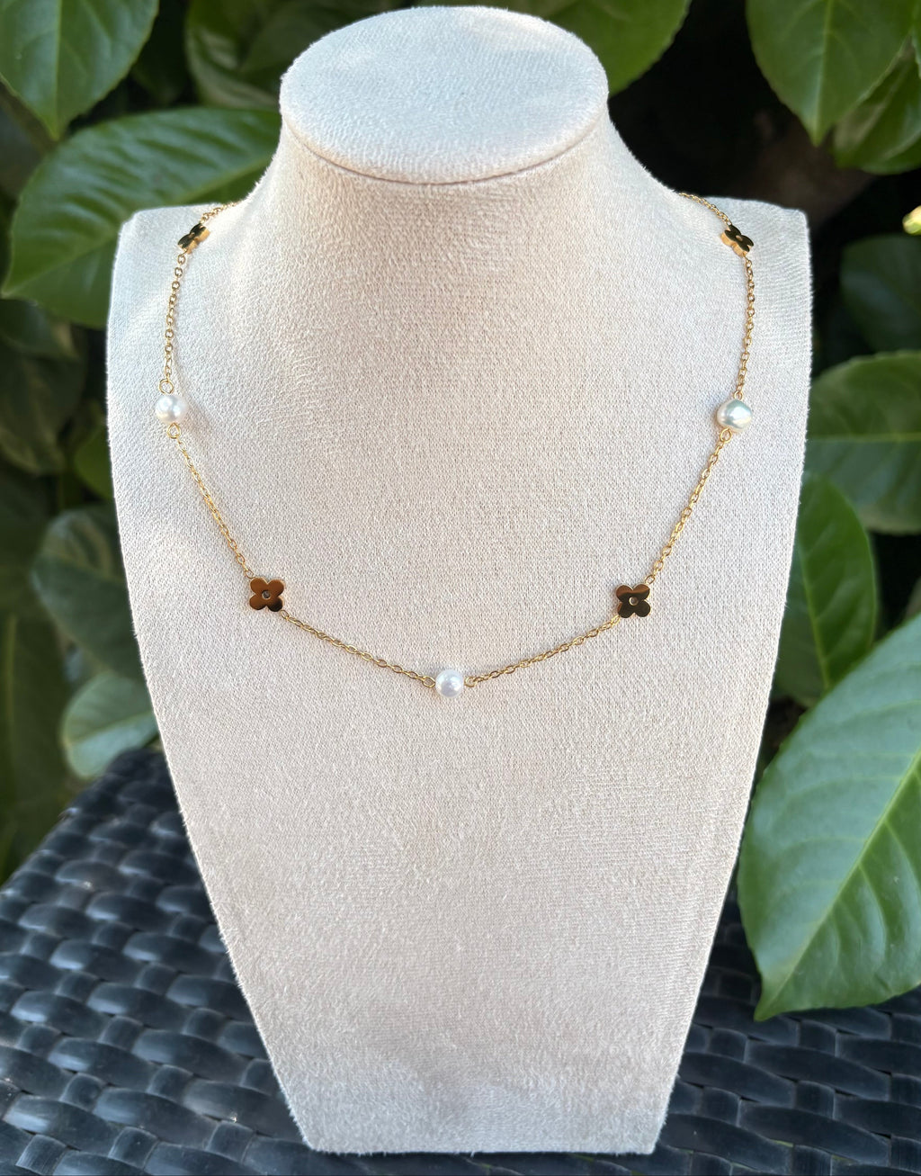 Collier fleurs dorées et perles blanches sur présentoir